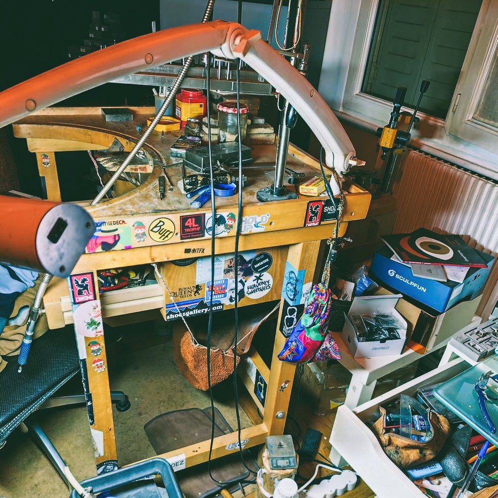 Établi atelier d'artisan bijoutier avec outils, lampe et poste de travail à Lyon, montrant l'authenticité de l'atelier Auclair-Création. fabrique cadeau artisanale
